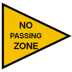 A yellow sign shaped like a horizontal triangle pointing right, with black lettering